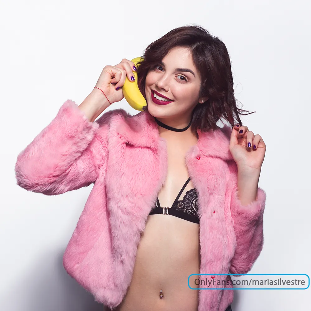 Chica simulando llamada telefónica y en la esquina inferior derecha se encuentra su user resaltado como marca de agua.